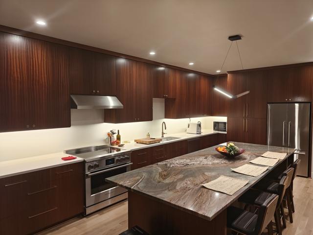 Finished kitchen with wood cabinetry and stone-topped island