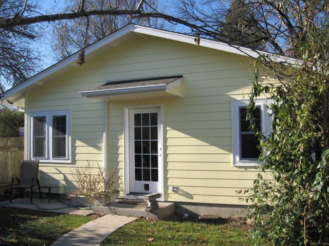 Yellow detached secondary dwelling unit (ADU) with French door and small entry roof