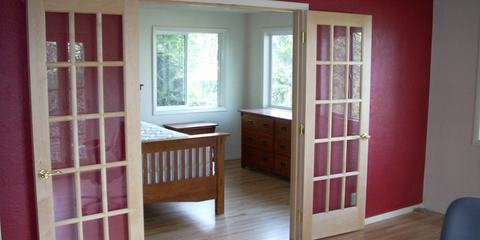 Remodeled room with red accent wall and French doors
